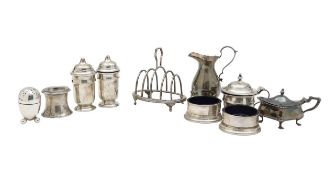 A collection of silver cruets, a cream jug and toast rack