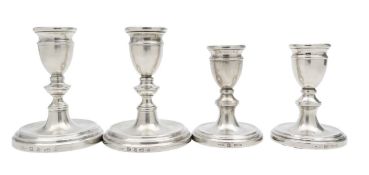 Two pairs of Elizabeth II silver dwarf candlesticks