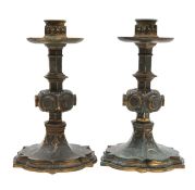 A pair of ecclesiastical style bronze candlesticks