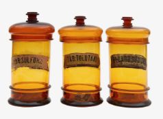 A group of three amber glass apothecary jars,