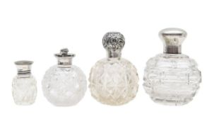 Four Victorian and George V silver topped glass perfume bottles,