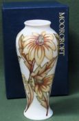 Boxed Moorcroft tubelined floral decorated glazed ceramic vase, stamped to base. Approx. 22cm H