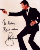 Roger Moore signed 1ox8inch colour photo. Dedicated.