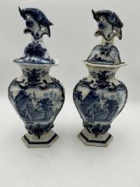 Pair of late 19th century delft lidded baluster vases the reserves with a rustic couple in