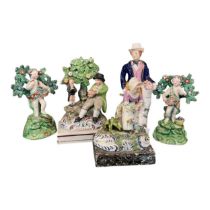 A 19th century figure of a country gentleman wearing a green coat and holding a bowl of fruit with a