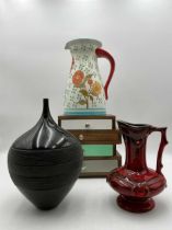 A miniature stepped chest of four drawers together with a polychrome jug with sunflower decoration