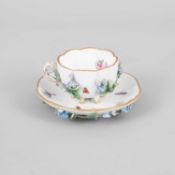 A small Meissen flower-encrusted cup and saucer