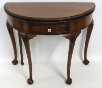 An antique style card table with ball & claw feet