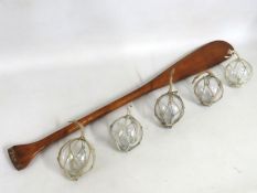 A wooden paddle 1050mm long, twinned with five gla