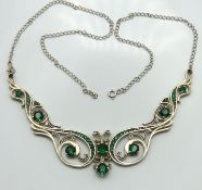 A sterling silver necklace set with green stones,