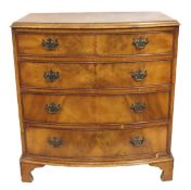 An antique walnut veneered bow fronted chest of dr