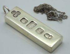 A 1977 silver ingot with an as found silver chain,