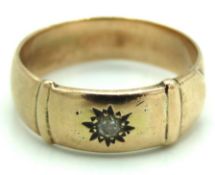 A yellow metal band set with 0.07ct of diamond, te