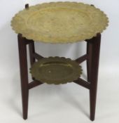 An early 20thC. two tier brass topped table with d