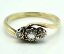 A yellow metal cross over style ring set with appr