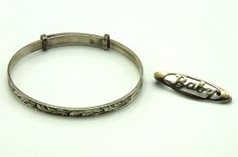 A child's adjustable silver bangle twinned with a