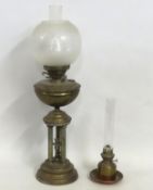 A brass oil lamp with decorative pedestal featuring three pillars around figure, 700mm tall, twinned