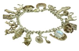 A silver charm bracelet set with various charms in