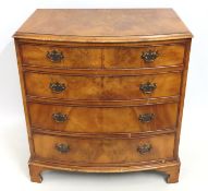 An antique walnut veneered bow fronted chest of dr