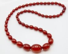 A set of antique natural red amber beads, largest