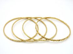Four yellow metal bangles, all test as 22ct gold,