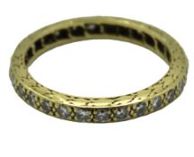 A yellow metal eternity ring with organic leaf des