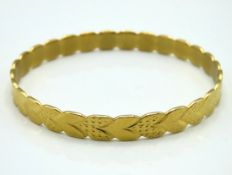A 22ct gold bangle with chevron decor, approx. 55.