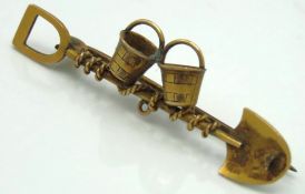 A yellow metal brooch depicting a prospectors spad
