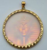 A yellow metal mounted hologram pendant depicting