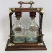 An antique oak & brass Tantalus with plated gin &