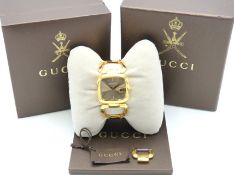 A Gucci G-Timeless watch with gold tone finish, box, paperwork & additional link, case 32mm x 30mm