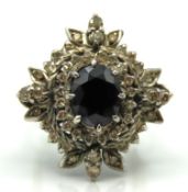 A white metal ring of organic form set with sapphi