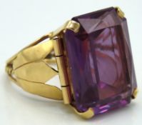 A yellow metal cocktail ring set with synthetic al