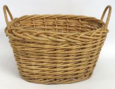 A wicker log basket, 490mm wide x 390mm deep x 260
