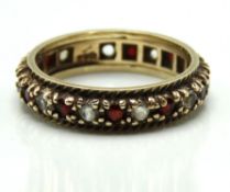A 9ct gold eternity ring set with white topaz & ga