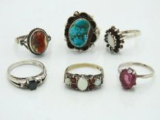 Six silver rings including one plated in gold & se