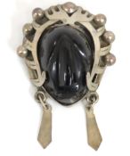 A Mexican silver carved onyx obsidian mask brooch,