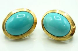 A pair of yellow metal earrings set with turquoise