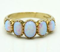 A 9ct gold ring set with five opals, 3.1g, size O