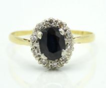 An 18ct gold ring set with 0.1ct of diamond around a central sapphire, 3.2g, size V