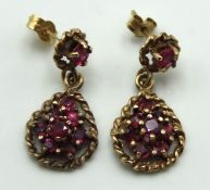 A pair of 9ct gold post fit earrings set with garn
