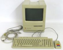 An Apple Macintosh Classic with keyboard, mouse &