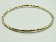 A 9ct two colour gold twist design bangle, 64mm di