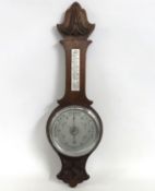 An oak cased silvered dial aneroid barometer with