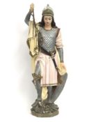 A plaster figure in armour standing over a dragon,