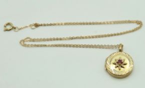 A 9ct gold locket pendant set with small ruby on a