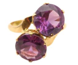 A yellow metal cross over ring set with colour change stones, possibly alexandrite, tests