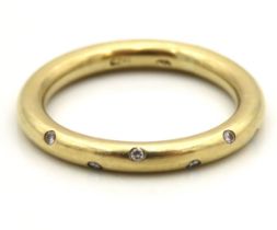 A yellow metal ring of round form set with five small diamonds, indistinct marks, tests