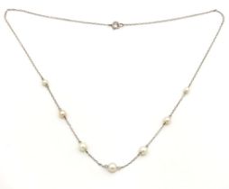 A white metal Edwardian pearl station necklace, tests electronically as 9ct gold, 400mm long, 2g