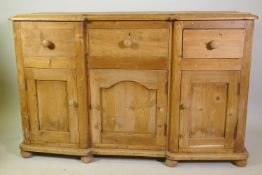 A stripped pine dresser with three drawers over three cupboards, raised on turned supports